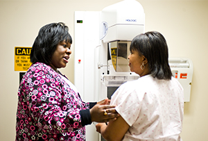 Nurse and woman at mammography machine